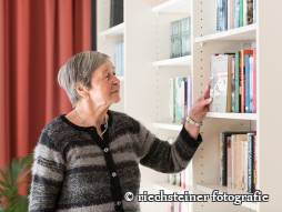 Frau vor dem Bücherregal