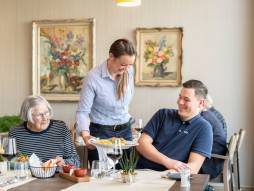 Mitarbeiterin serviert Gästen Essen im Restaurant