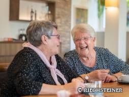 zwei Frauen sitzen gemeinsam und geniessen ein Kaffee
