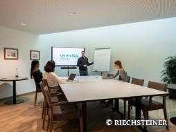 Mitarbeitende hören bei einer Präsentation über Food Waste im Sitzungszimmer zu