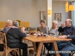 vier Frauen und zwei Männer am Tisch am Kaffee geniesse und plaudern