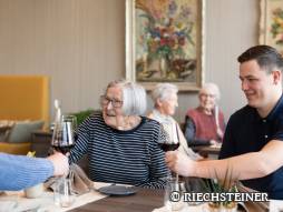 Drei Personen im Restaurant am anstossen mit Wein
