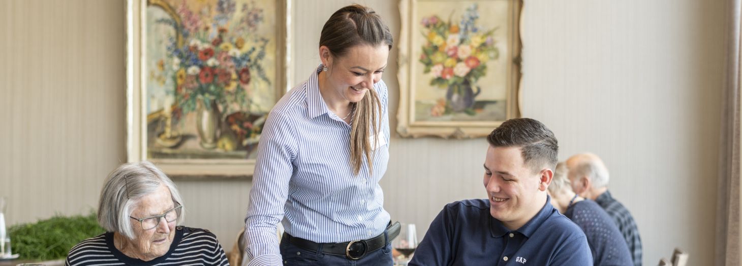 Frau serviert zwei Personen Essen im Restaurant