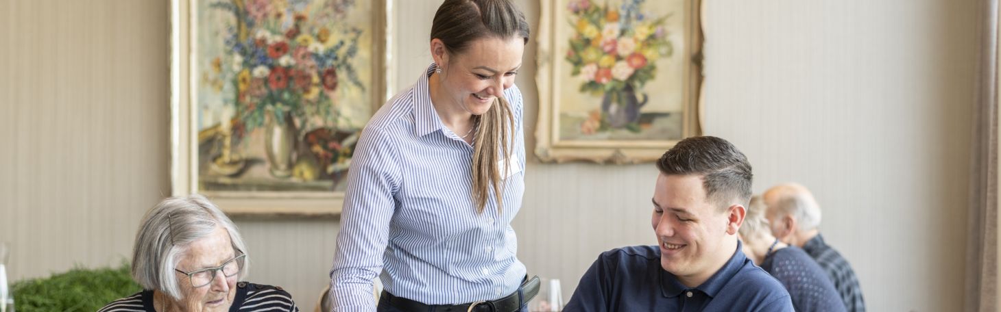 Frau serviert zwei Personen Essen im Restaurant