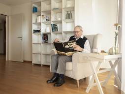 Mann sitzt auf dem Sessel und liest