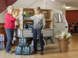 Zwei Frauen vor einem Wagen mit Wasser und Produkten