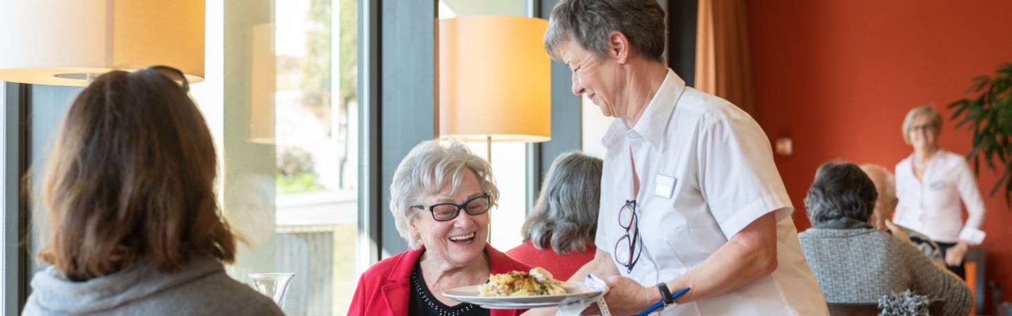 Frau serviert zwei Personen Essen