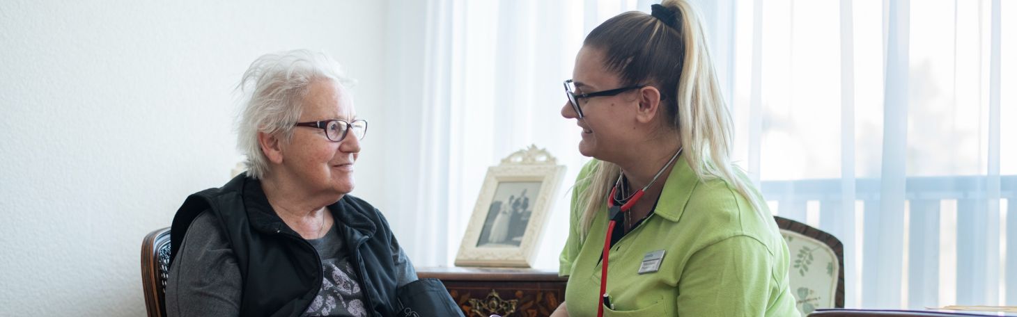 Pflegerin misst Frau Blutdruck