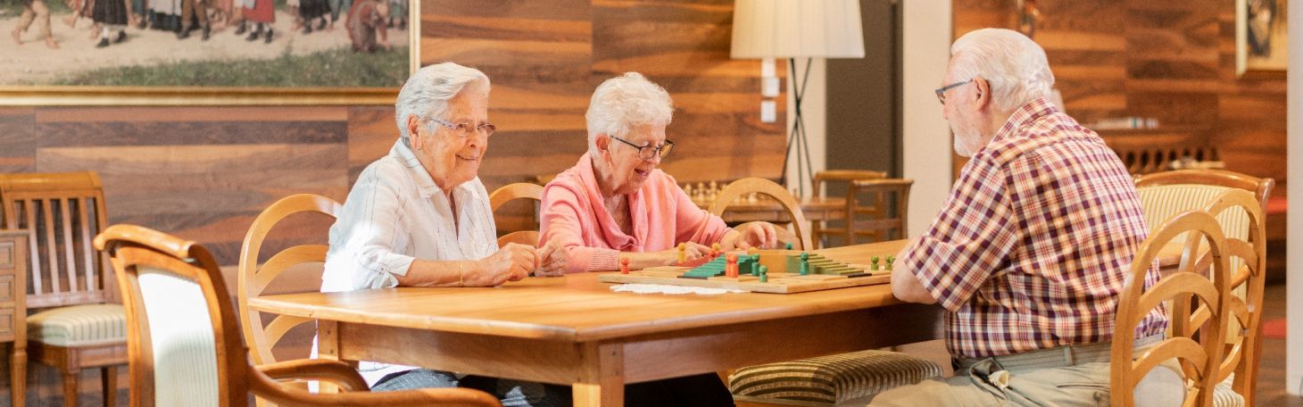 Drei Personen am Tisch spielen