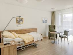 Pflegezimmer mit Bett und Sessel