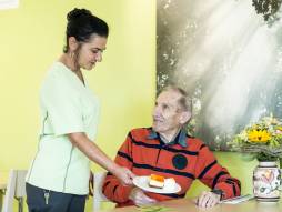 Mitarbeiterin serviert Essen