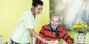 Mitarbeiterin serviert Essen