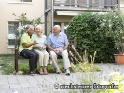 drei Bewohnende auf der Bank
