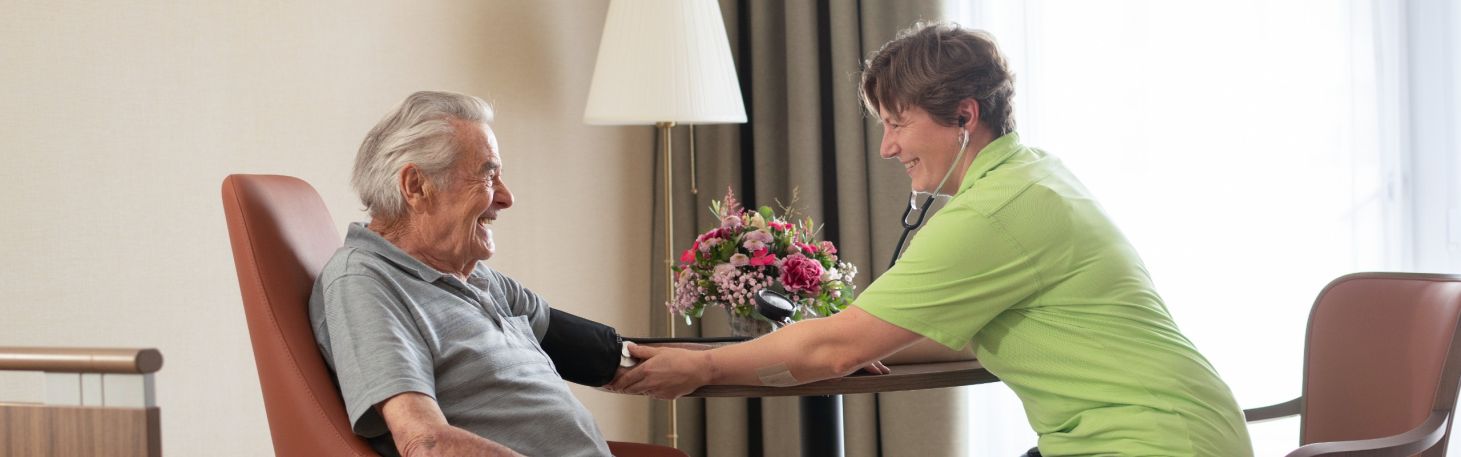 Frau misst Mann Blutdruck