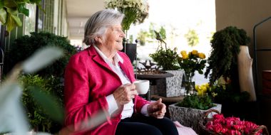 Frau geniesst draussen ihren Kaffee