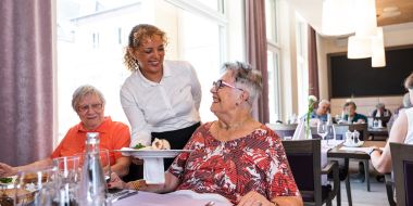 Frau seviert Essen an