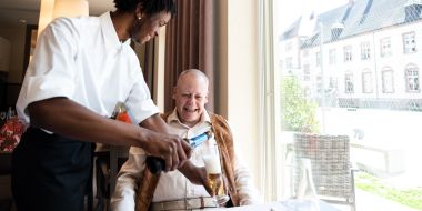 Mitarbeiter serviert Trinken an