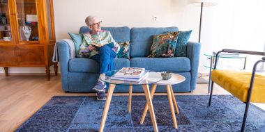 Frau liest Buch auf dem Sofa