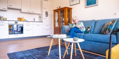 Frau liest Buch auf dem Sofa
