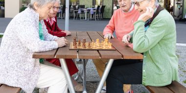 Vier Personen spielen Schach draussen
