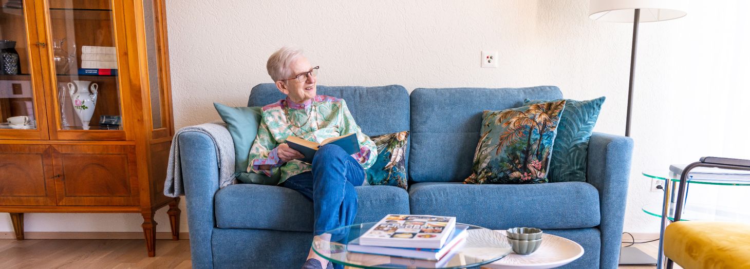 Dame sitzt auf dem Sofa