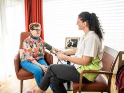 Mitarbeiterin misst Bewohnerin Blutdruck