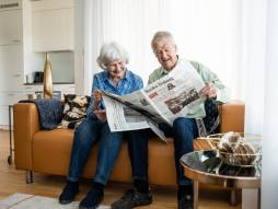 zwei Personen am Zeitung lesen