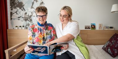 Mitarbeiterin und Bewohnerin lesen ein Magazin