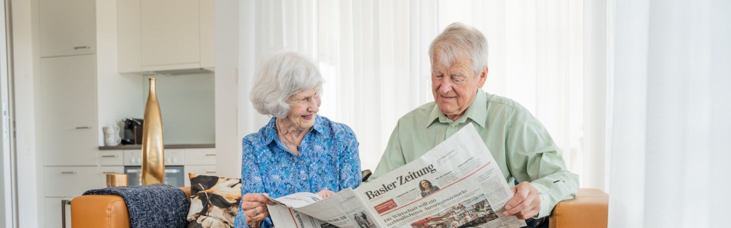 Bewohnende auf dem Sofa am Zeitung lesen