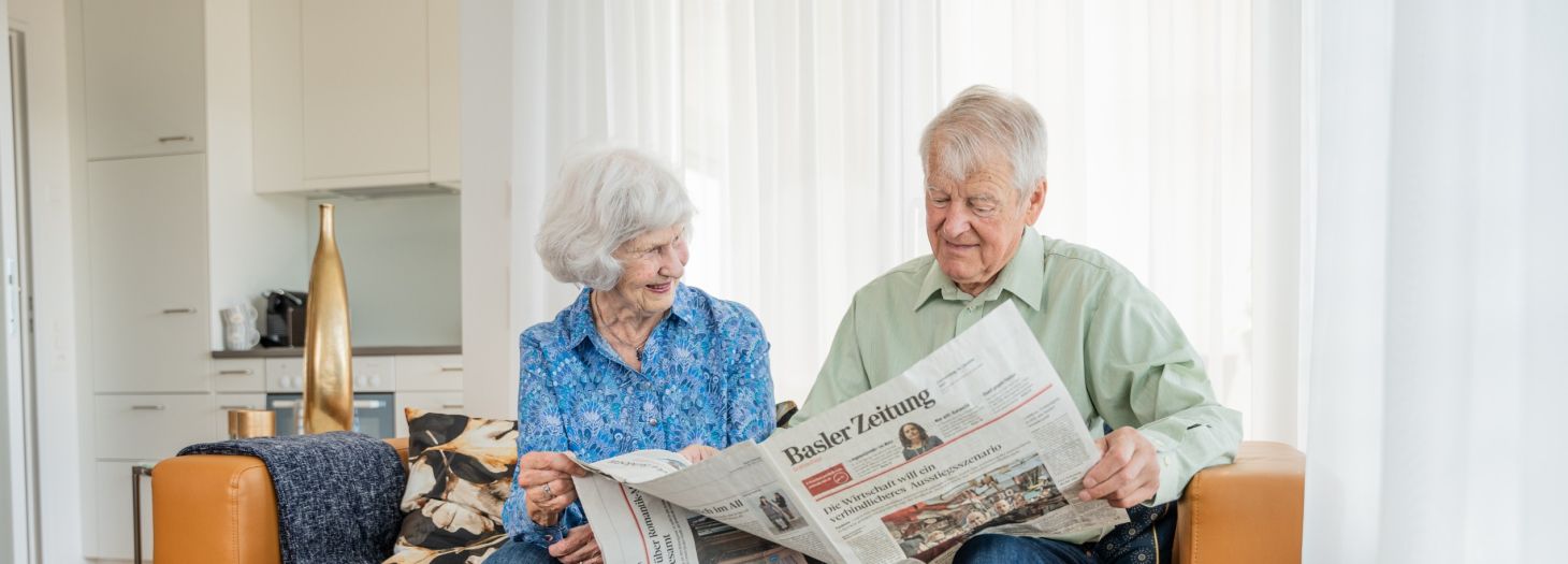 Bewohnende auf dem Sofa am Zeitung lesen