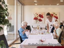 Mitarbeiterin bedient Bewohnende