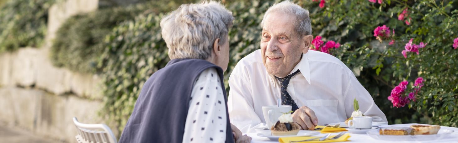 Mann und Frau am Tisch draussen