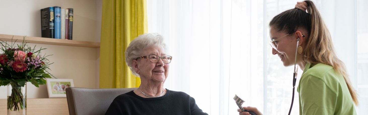 Pflegerin misst Bewohnerin Blutdruck