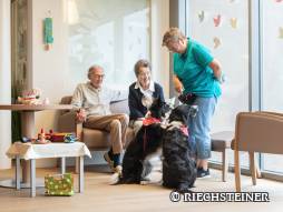 Drei Personen mit Hund