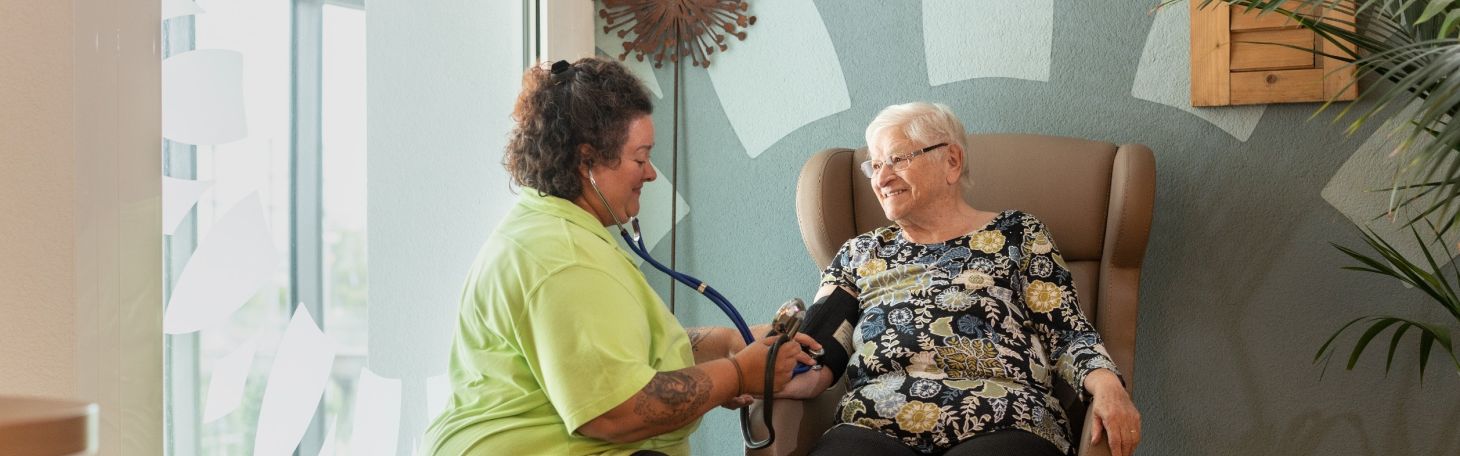 Mitarbeiterin misst Bewohnerin Blutdruck