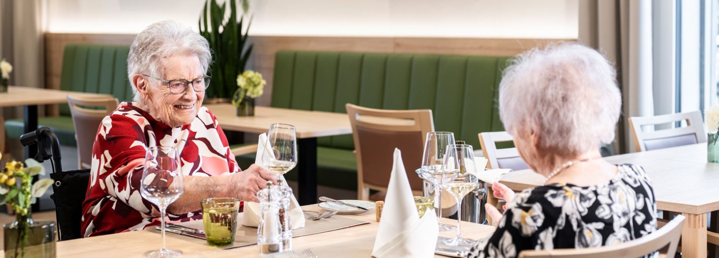 Zwei Damen am Tisch werden vom Servicepersonal zum Mittagessen bedient