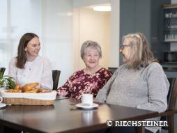 drei Personen am Tisch am Kaffee trinken