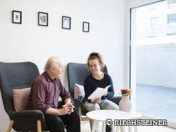 drei Personen auf dem Sessel am lesen