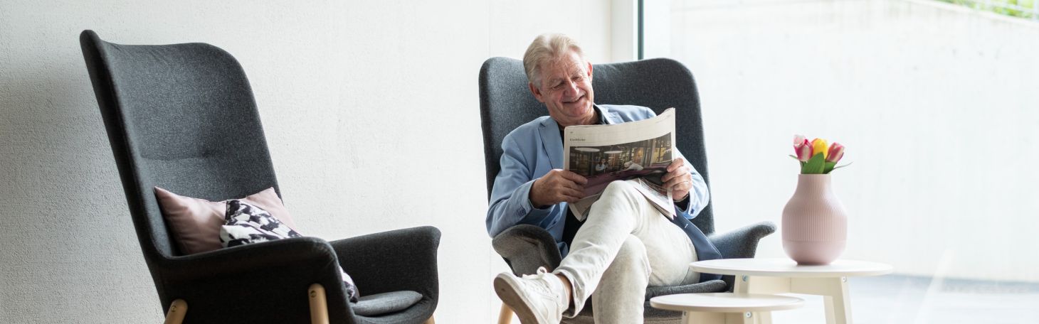 Mann auf Sessel und liest