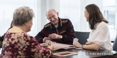 vier Personen spielen Karten