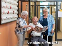 zwei Personen zeigen Mann auf Magazin