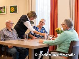 Mitarbeiterin serviert 3 Personen